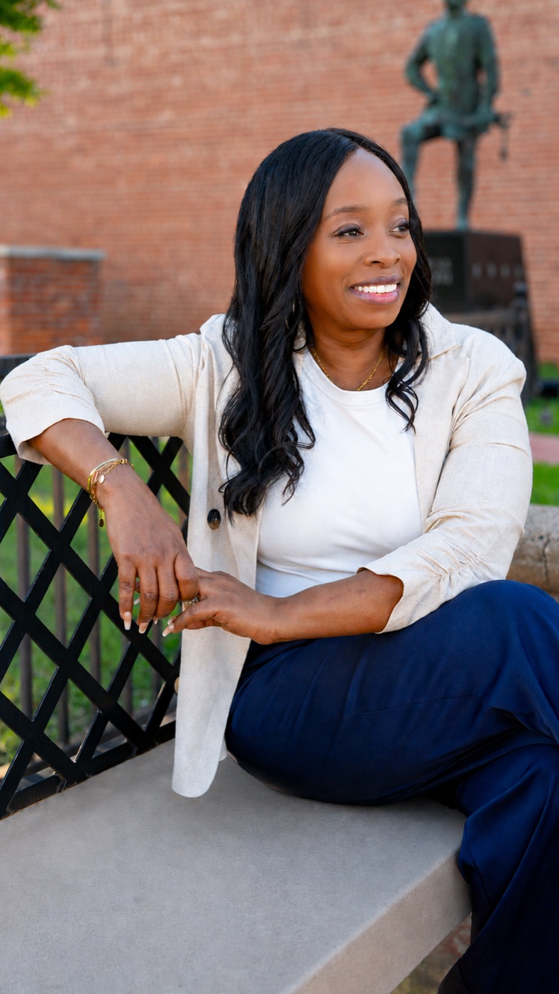 Executive portrait seated outdoors near a historic building