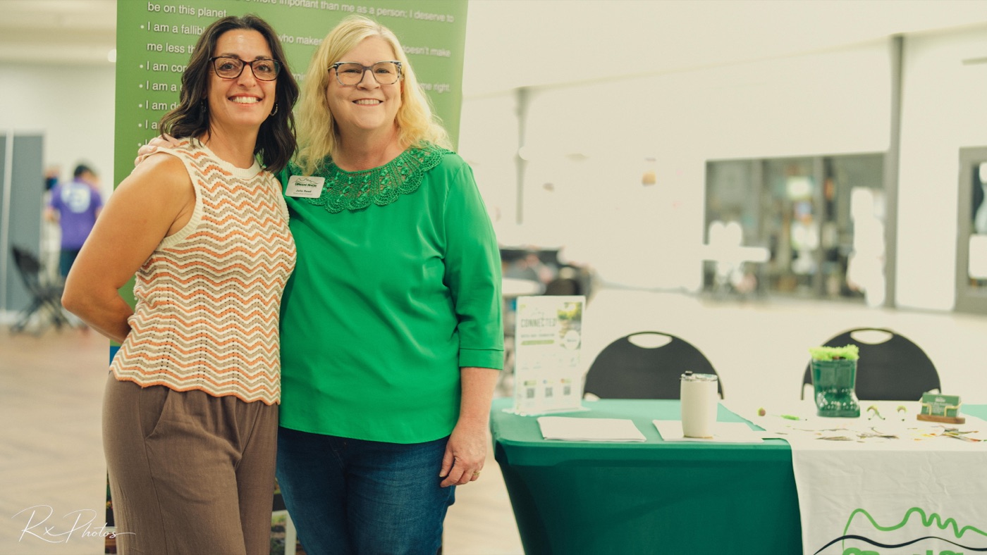 Team members posing together at a corporate event booth